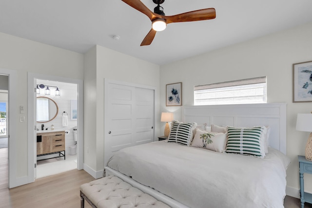 bedroom featuring a closet, light wood finished floors, multiple windows, and baseboards