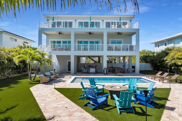 rear view of house with a yard, a ceiling fan, a patio, and a balcony