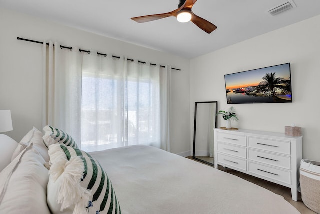 bedroom with wood finished floors, ceiling fan, and visible vents