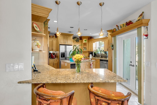 kitchen featuring a peninsula, stainless steel appliances, a kitchen breakfast bar, open shelves, and glass insert cabinets