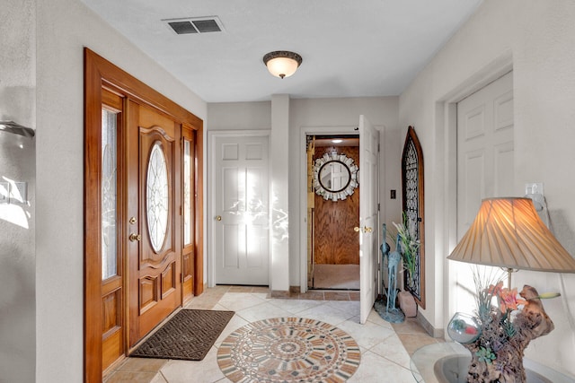 foyer entrance featuring light tile patterned floors, visible vents, and baseboards