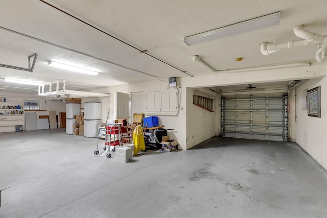 garage featuring white fridge and freestanding refrigerator