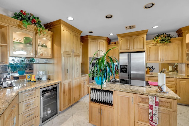 kitchen featuring stainless steel appliances, visible vents, glass insert cabinets, light stone countertops, and beverage cooler