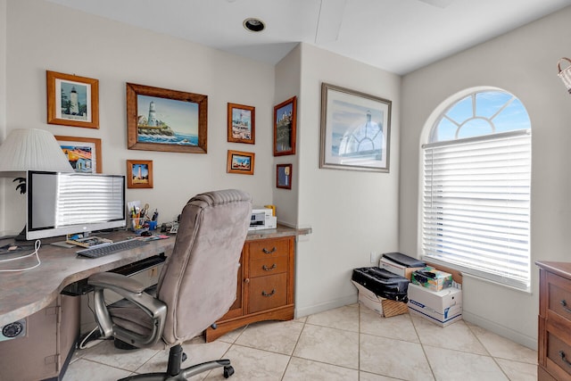 home office with light tile patterned floors, baseboards, and a wealth of natural light