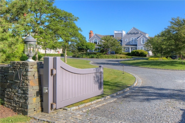 view of gate with a yard