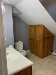 bathroom featuring vaulted ceiling, toilet, and vanity