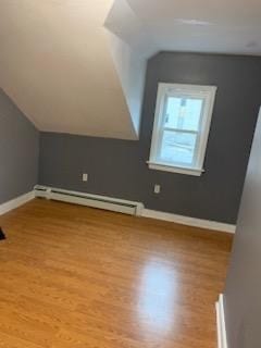 bonus room featuring vaulted ceiling, a baseboard radiator, and light wood-type flooring