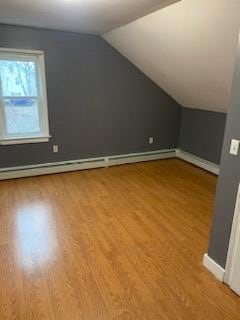 bonus room featuring lofted ceiling, a baseboard heating unit, and hardwood / wood-style floors