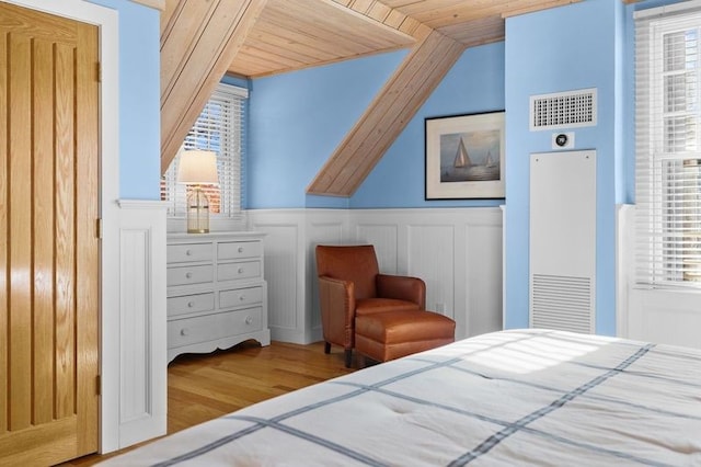 bedroom with multiple windows, wood ceiling, vaulted ceiling, and hardwood / wood-style flooring