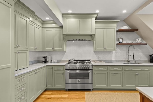 kitchen featuring decorative backsplash, sink, light hardwood / wood-style flooring, green cabinetry, and high end stainless steel range