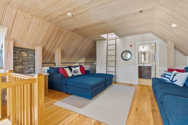 living room featuring lofted ceiling, light wood-type flooring, and wooden ceiling