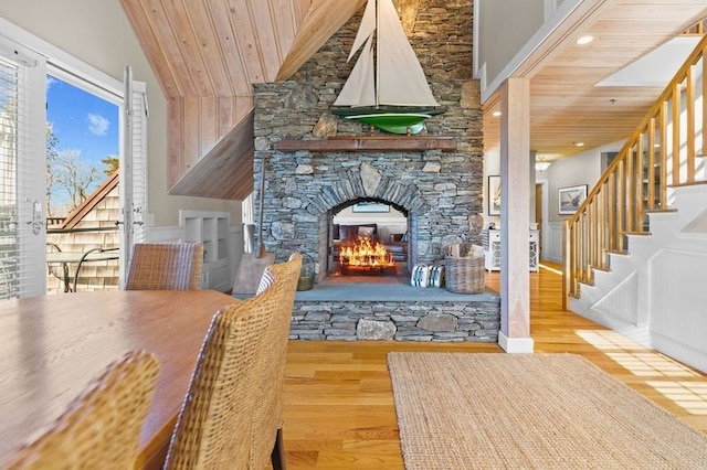 unfurnished dining area with light hardwood / wood-style floors, wood ceiling, and a fireplace