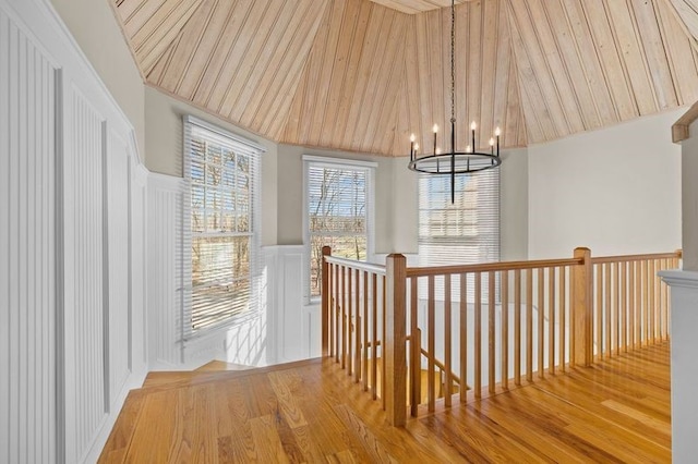 corridor with wooden ceiling, hardwood / wood-style flooring, and a notable chandelier