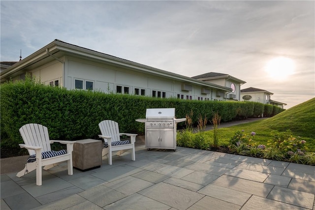 patio terrace at dusk featuring a grill