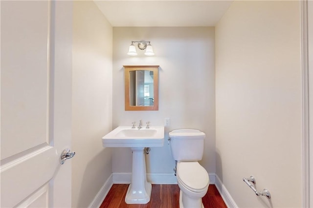 bathroom featuring hardwood / wood-style flooring and toilet