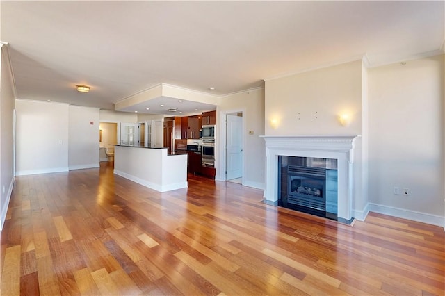 unfurnished living room featuring hardwood / wood-style flooring, a fireplace, and ornamental molding