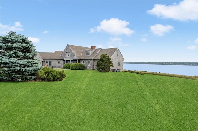 cape cod home featuring a water view and a front lawn