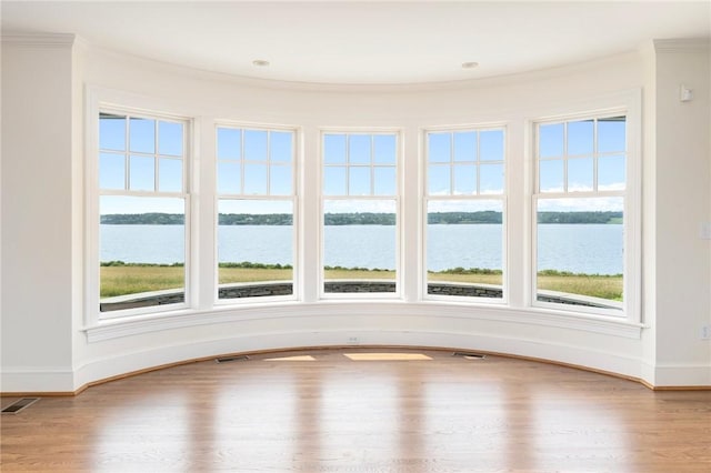 unfurnished sunroom featuring a water view