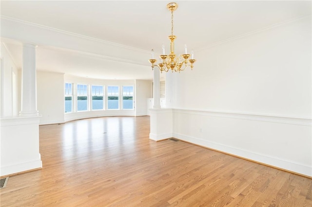 unfurnished room featuring crown molding, light wood-type flooring, decorative columns, and a water view