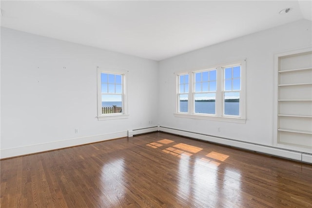 unfurnished room with wood-type flooring, a water view, a baseboard radiator, and built in shelves