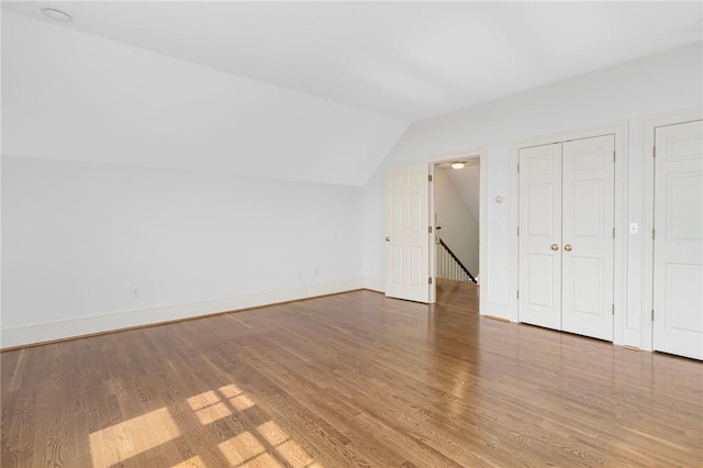 additional living space featuring hardwood / wood-style flooring and lofted ceiling