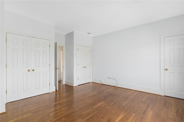 unfurnished bedroom featuring dark wood-type flooring and a closet