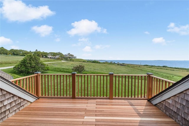 wooden terrace featuring a water view and a lawn