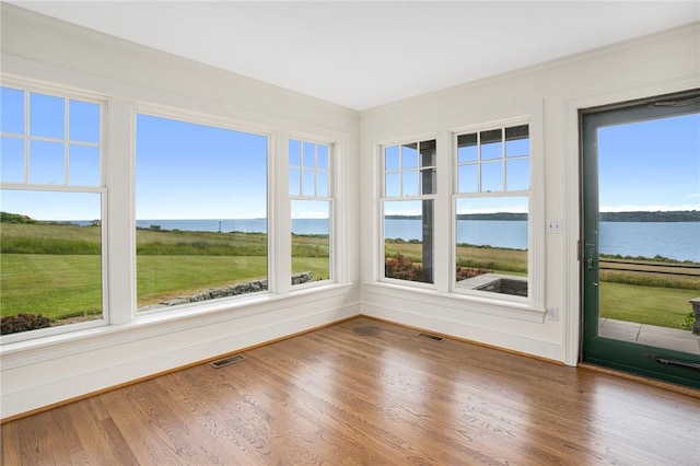 unfurnished sunroom featuring a water view and a healthy amount of sunlight