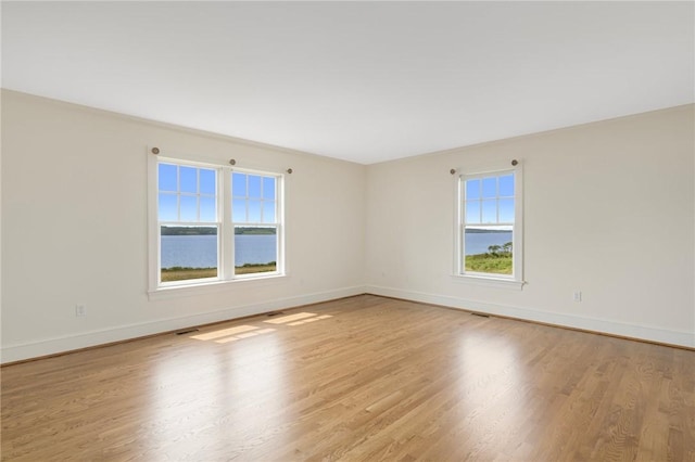 empty room with a water view and light wood-type flooring