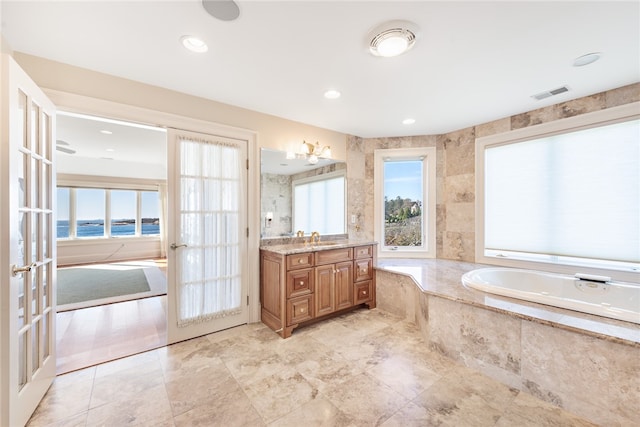 bathroom featuring french doors, vanity, tile floors, and tiled bath