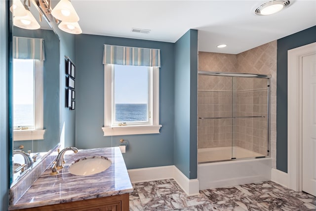 bathroom featuring enclosed tub / shower combo, vanity with extensive cabinet space, tile floors, and a healthy amount of sunlight