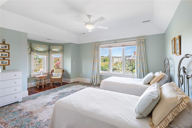 bedroom featuring wood-type flooring, ceiling fan, vaulted ceiling, and multiple windows