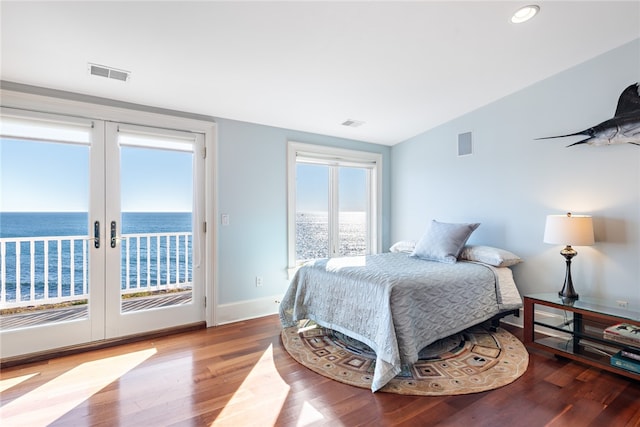 bedroom featuring french doors, multiple windows, access to outside, and hardwood / wood-style flooring