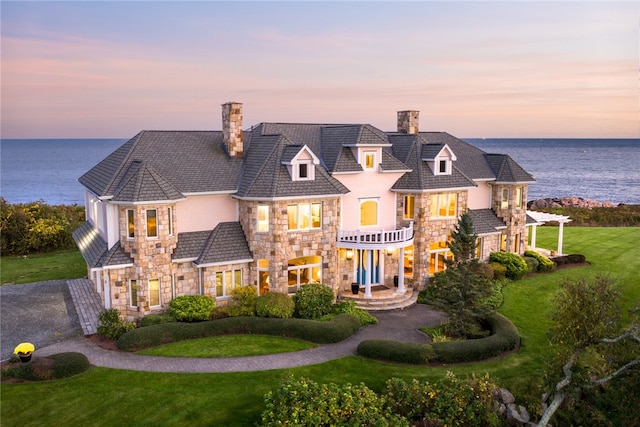 view of front of home featuring a water view and a lawn