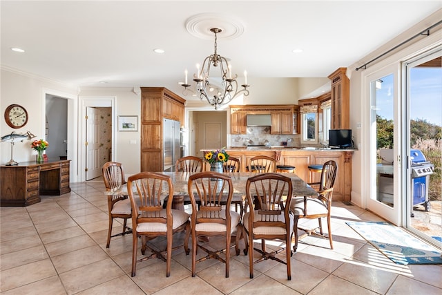 dining area with crown molding, light tile floors, and a notable chandelier