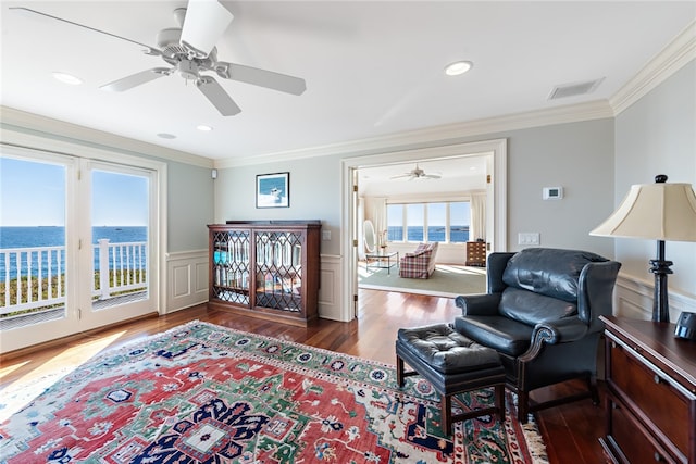 bedroom with ceiling fan, a water view, access to exterior, dark hardwood / wood-style flooring, and ornamental molding