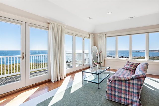 living room featuring french doors, hardwood / wood-style floors, and a water view