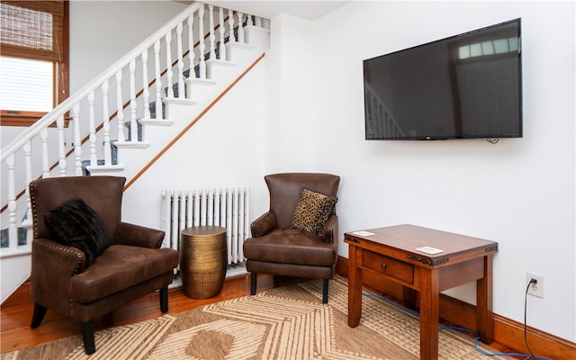 living area with light wood-type flooring and radiator heating unit