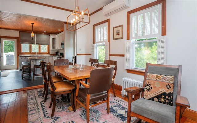 dining space with radiator heating unit, a wall mounted AC, a healthy amount of sunlight, and hardwood / wood-style floors