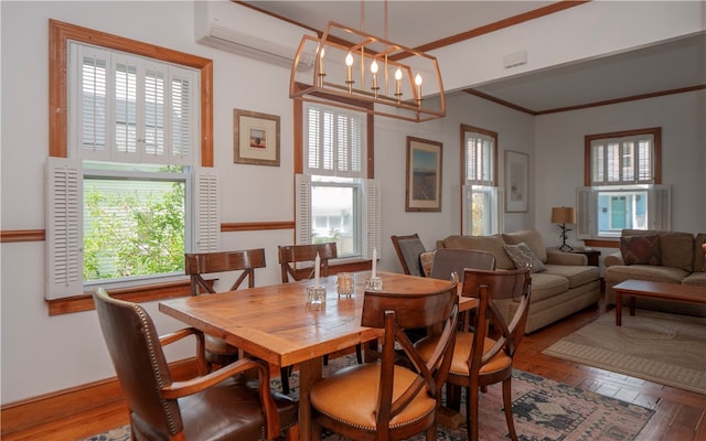 dining area featuring hardwood / wood-style flooring, ornamental molding, and a chandelier