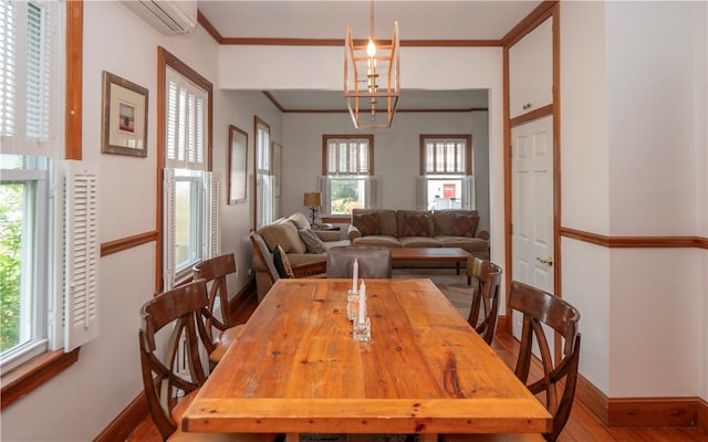 dining area with a wall mounted AC, a wealth of natural light, and hardwood / wood-style floors