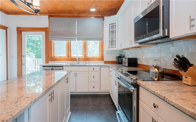 kitchen featuring light stone countertops, stainless steel appliances, white cabinetry, and sink