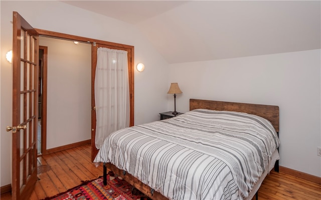 bedroom featuring vaulted ceiling and hardwood / wood-style flooring