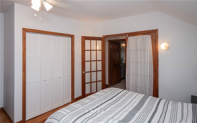 bedroom featuring ceiling fan, vaulted ceiling, wood-type flooring, and a closet