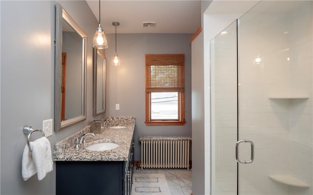 bathroom with vanity, a shower with shower door, and radiator