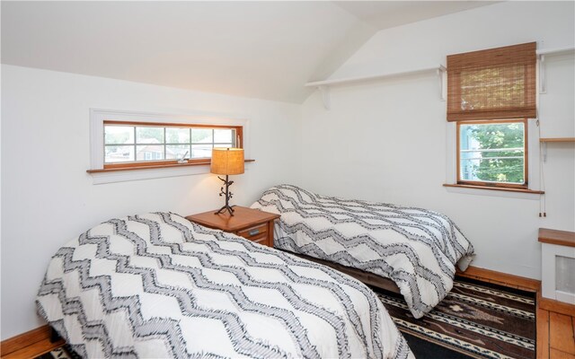 bedroom with vaulted ceiling and multiple windows