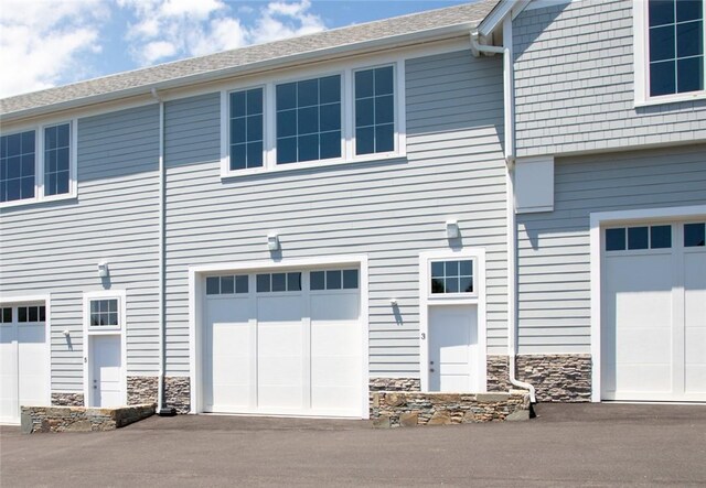 55 John Clarke Rd Unit 3, Middletown, RI 02842 - back of property with stone siding and an attached garage