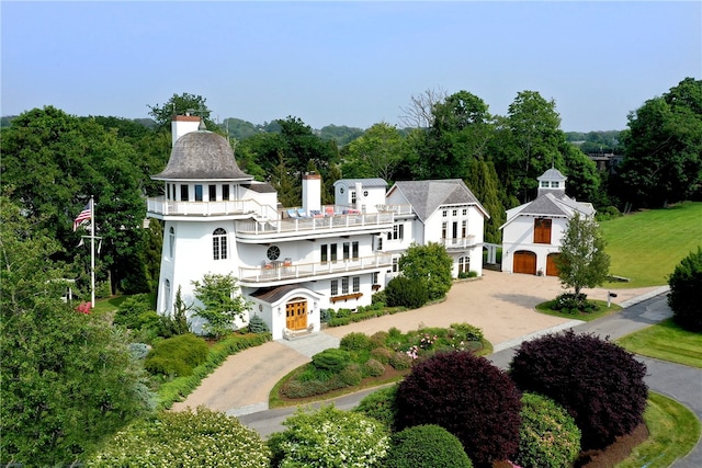 exterior space with a garage, a balcony, and a lawn