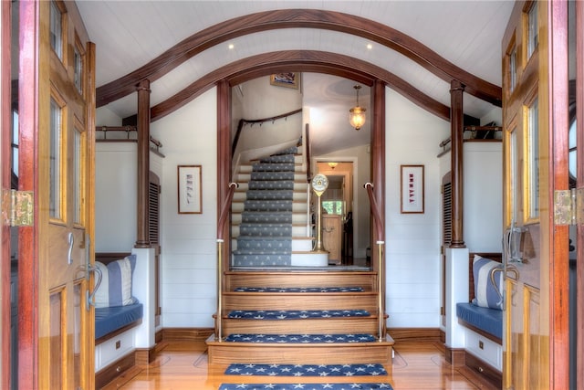 stairs with hardwood / wood-style flooring and lofted ceiling with beams