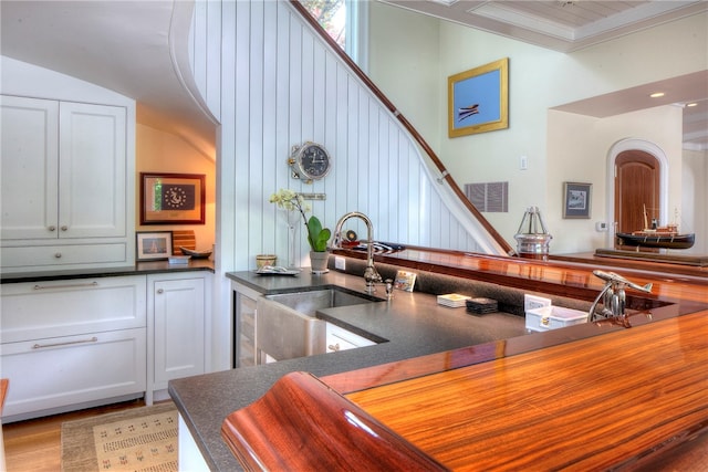 kitchen featuring beverage cooler, hardwood / wood-style flooring, crown molding, white cabinets, and sink